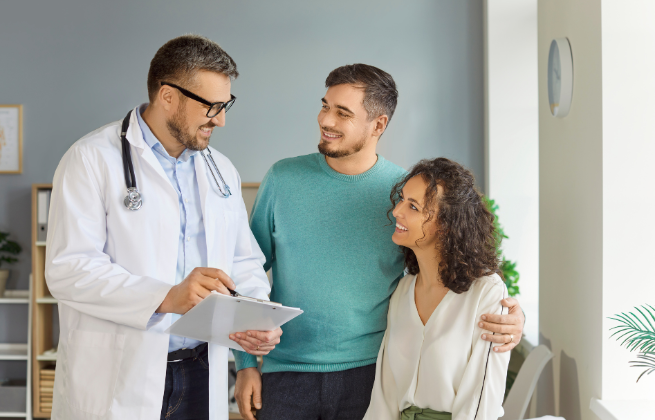 Lekarz omawia wyniki badań z parą planującą ciążę podczas konsultacji.